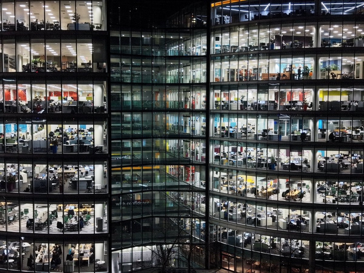Illuminated glass facade of a modern commercial building at night